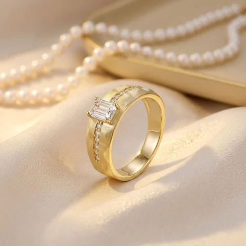 Product photograph showing the emerald bezel-set ring.