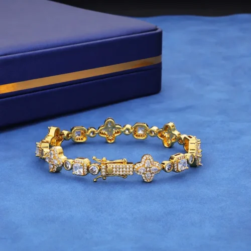 Gold-tone four-leaf clover bracelet with round and square stone settings and a box clasp.
