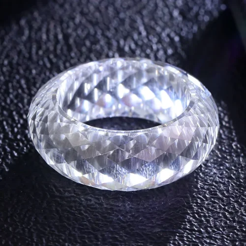 Product photograph showing the transparent faceted band ring.