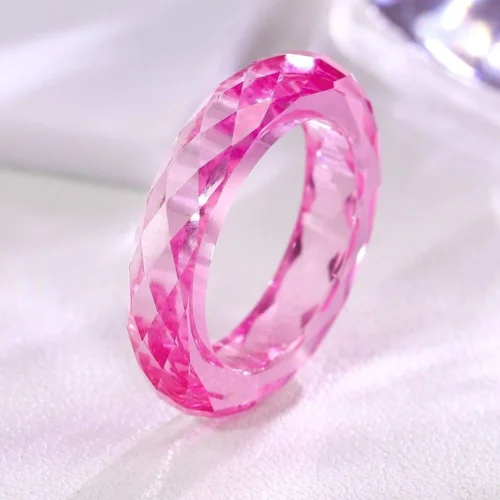 Product photograph showing the transparent faceted band ring.