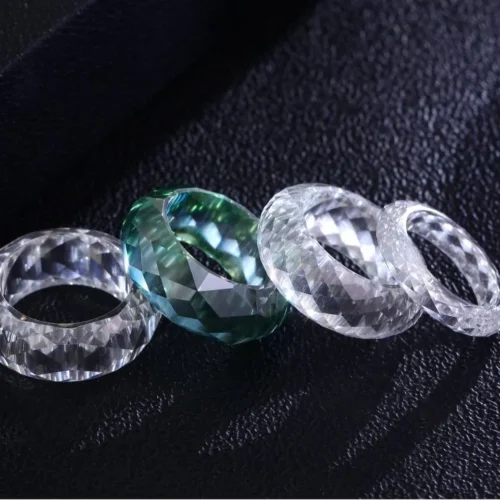 Product photograph showing the transparent faceted band ring.