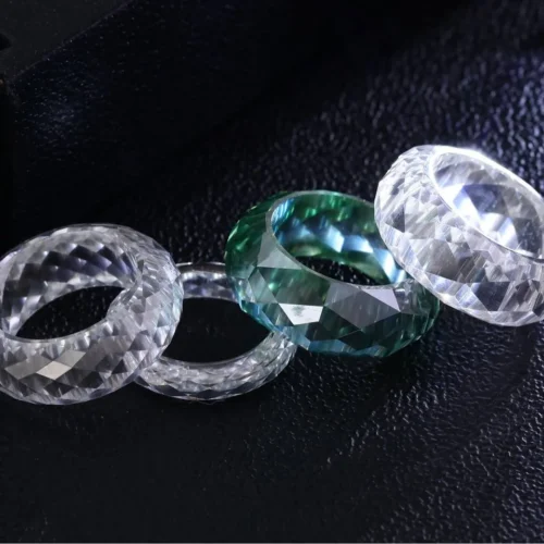 Product photograph showing the transparent faceted band ring.